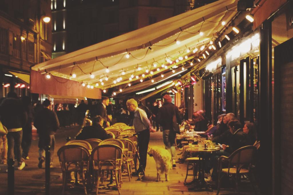 des gens en terrasse d'un restaurant la nuit