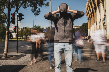 vue d'un homme se bouchant les oreilles dans la rue