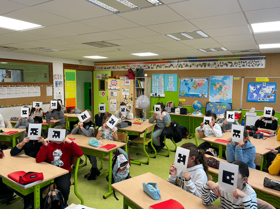 salle de classe dans laquelle les élèves présentent des QR codes devant leur tête