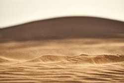 dune_de_sable_avec_du_vent_qui_fait_flotter_le_sable_dans_l_air