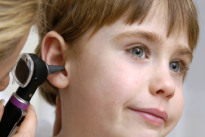 ado regardant son portable dehors avec des ecouteurs dans les oreilles