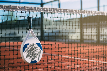 raquette de padel laissée sur un filet