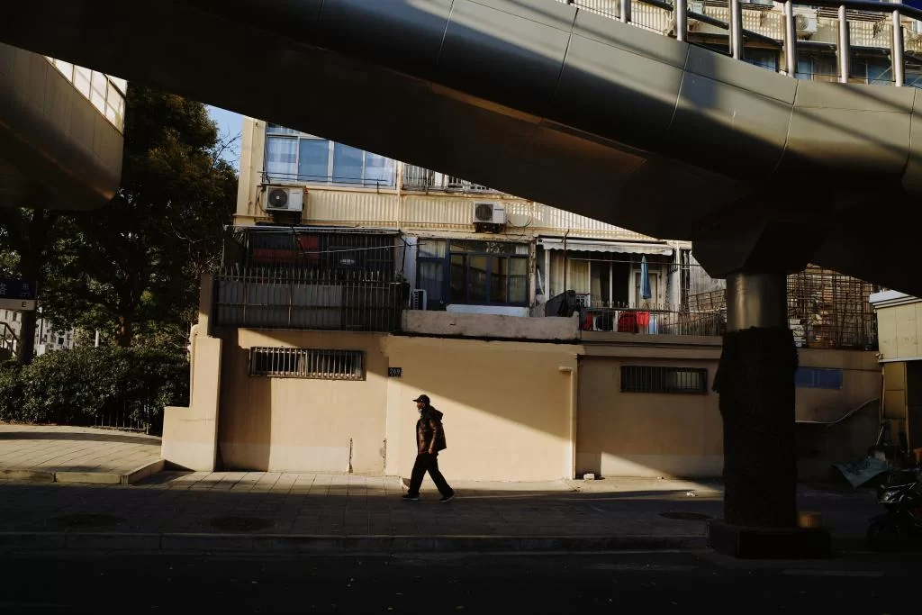 photo d'une rue ensoleillée d'une ville dense dans laquelle un homme passe