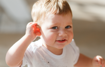 enfant se tenant l'oreille pour écouter