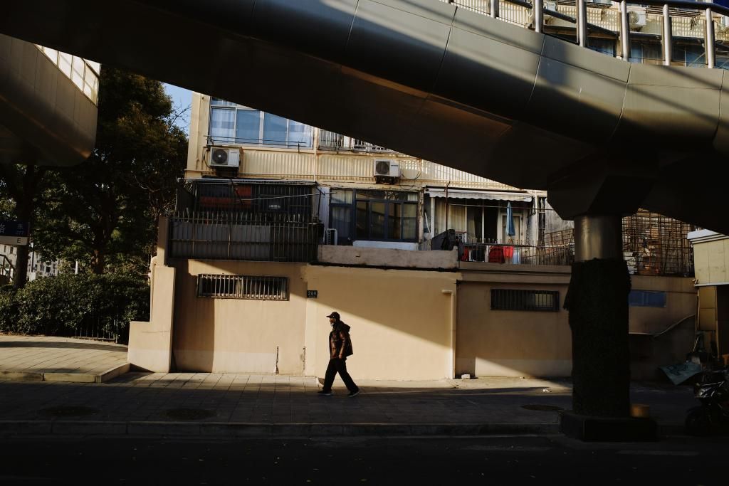 photo d'une rue ensoleillée d'une ville dense dans laquelle un homme passe